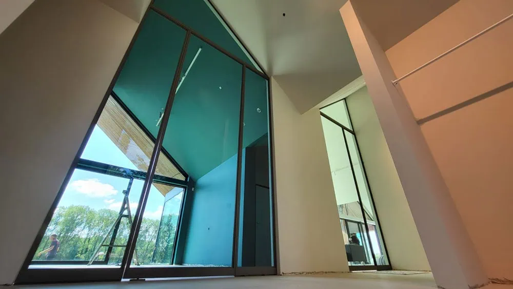 steel look in anodic bronze met groen glas